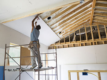 A construction specialist working on the ceiling